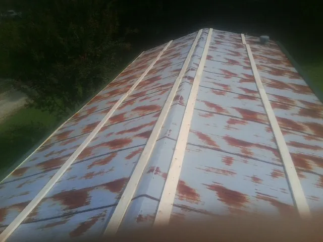 Rusted metal roof panels with new wood purlins before replacement — Storm Damage Roof Repair in Signal Hill by Roofing Brothers