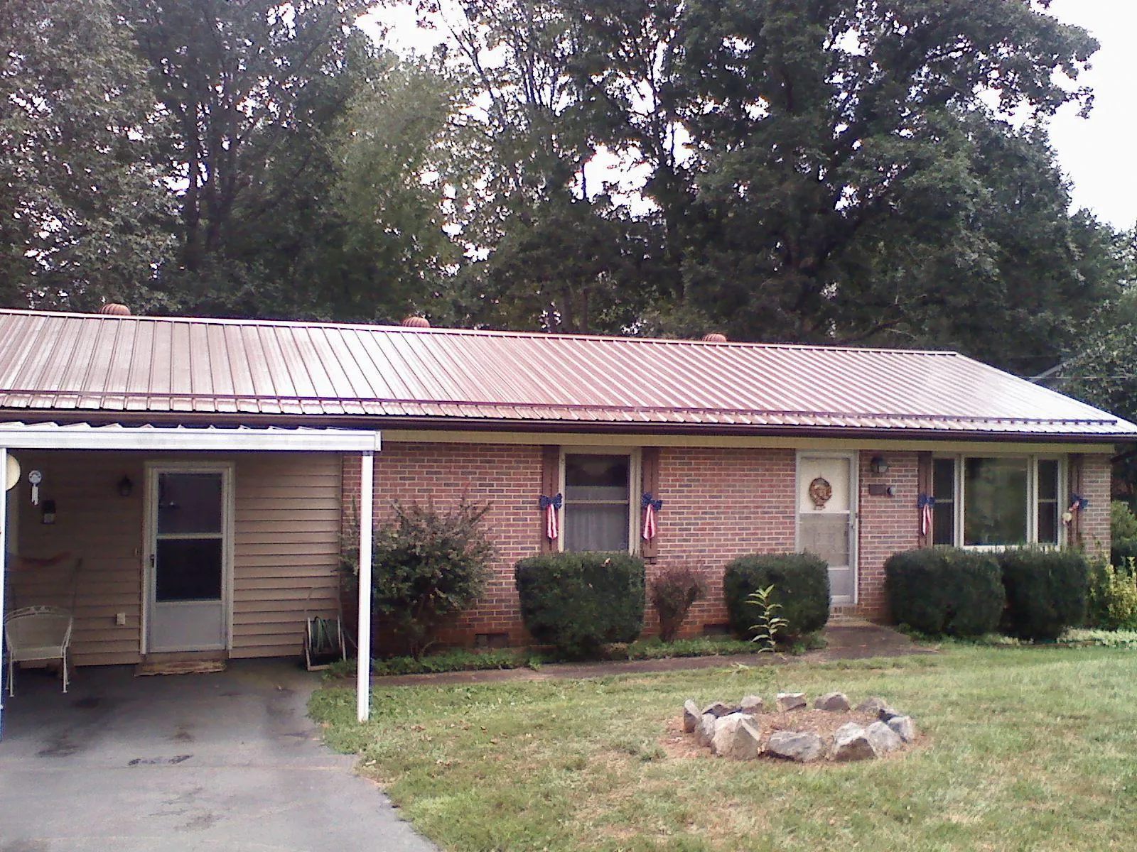 Bronze metal roof and carport on a brick ranch home — Roof Repair work by our crew in Signal Hill
