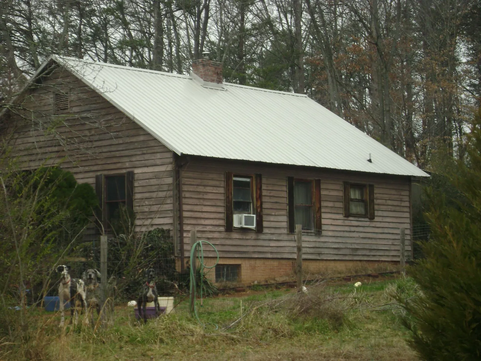 White metal roof on an old wood sided farmhouse, from a Metal Roof Installation job in Signal Hill